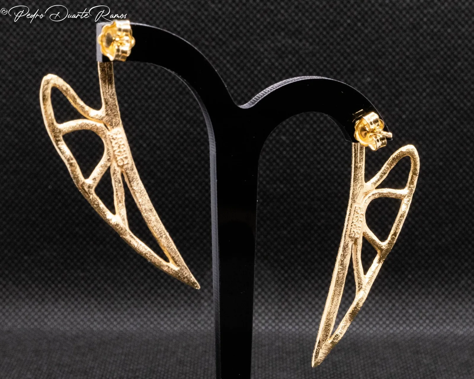 Pair of pierced gold leaf earrings on black